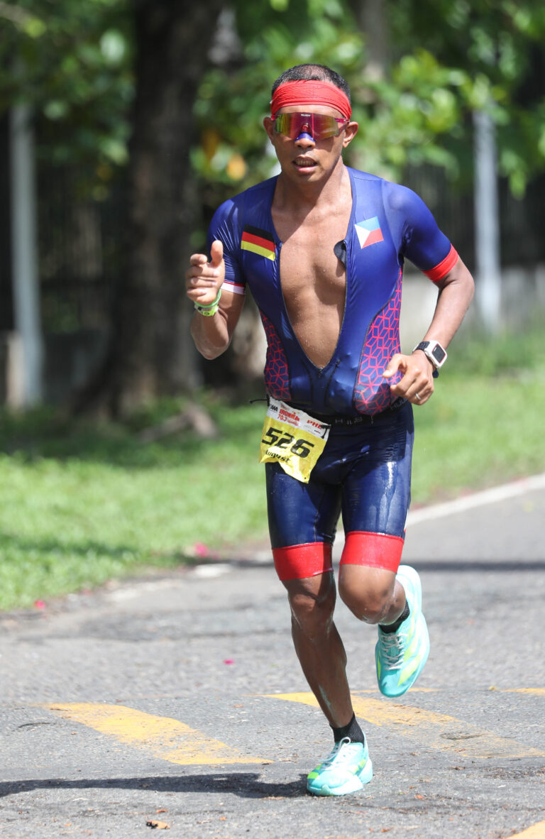 August Benedicto running during a triathlon