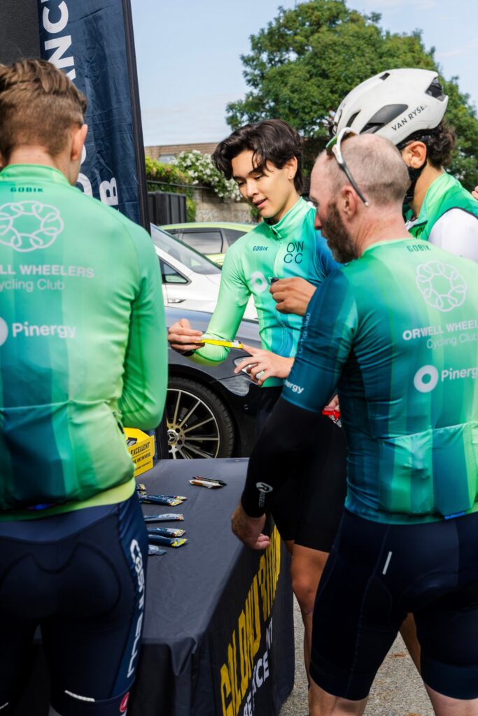 Cyclists choosing nutrition bars at a table outside the Endurance Lab studio