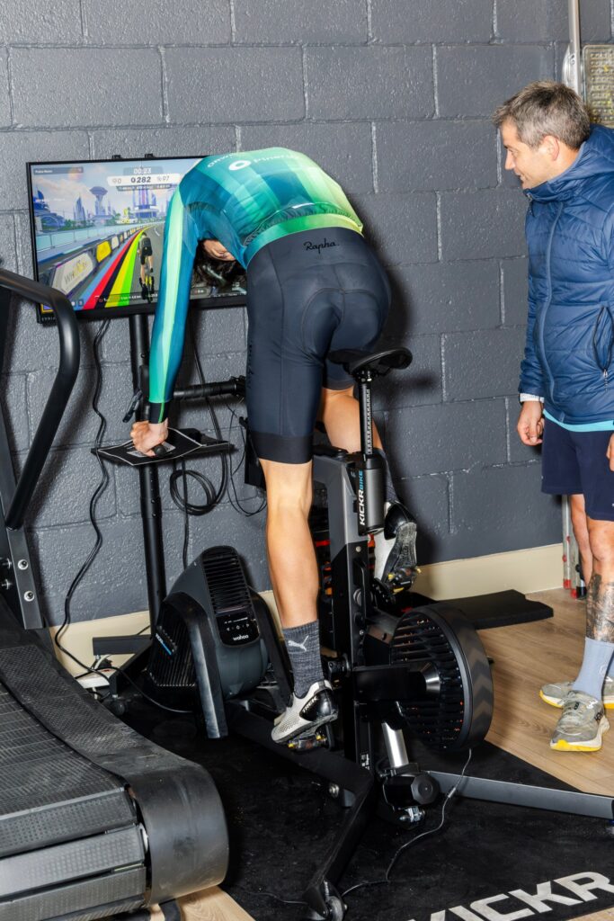 Cyclist doing a test on a Wahoo KICKR bike while an Endurance Lab coach watches