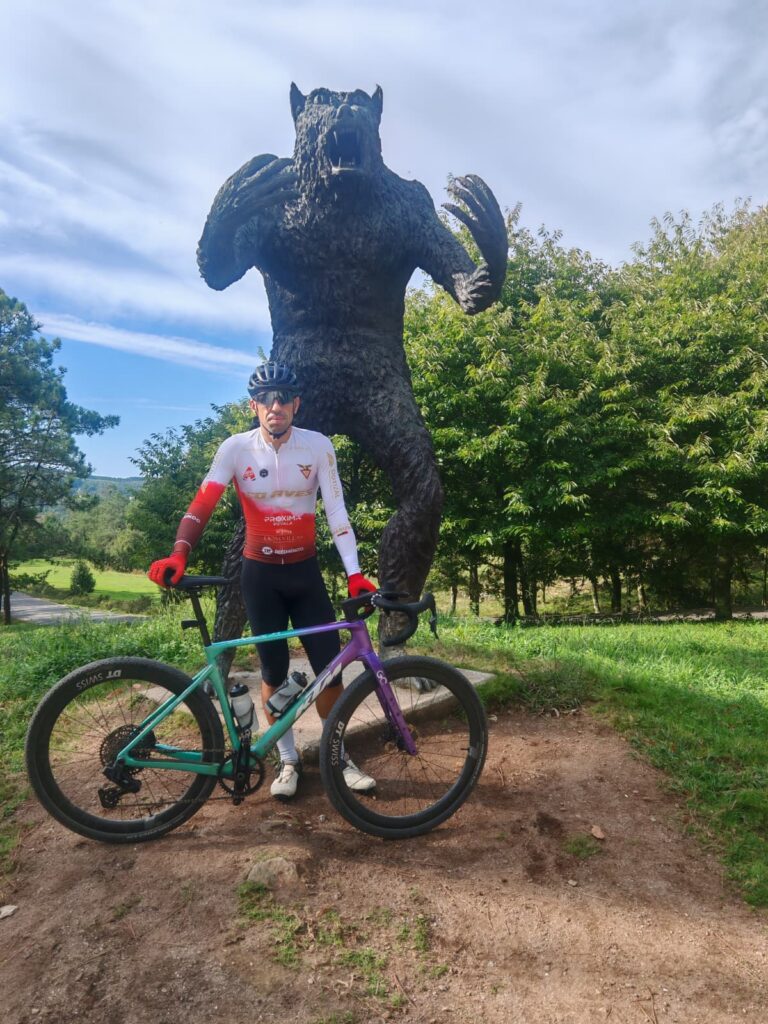Sérgio Rego, Endurance Lab XCM mountain biker, standing with his mountain bike in front of a large sculpture