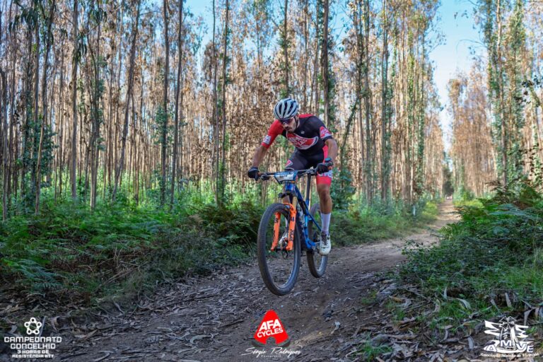 Tiago Meireles riding his mountain bike along a forest trail during an XCM race